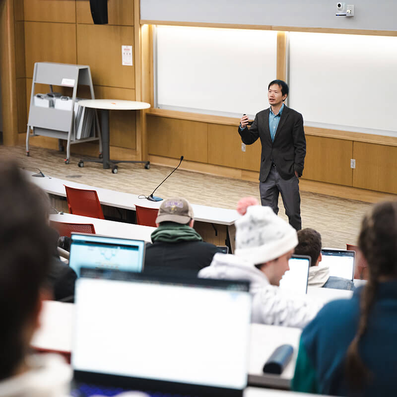Students in classroom listen to professor's lecture.